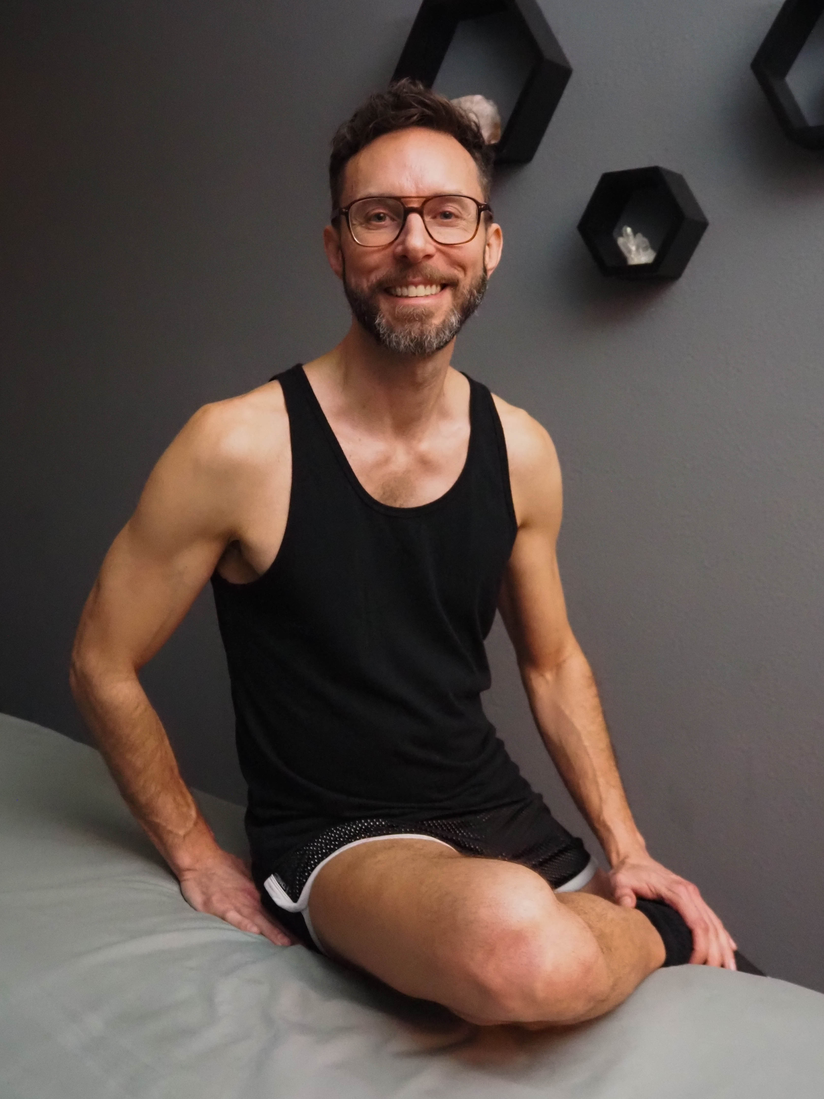 Portrait of Jonathan Reese sitting on a massage table